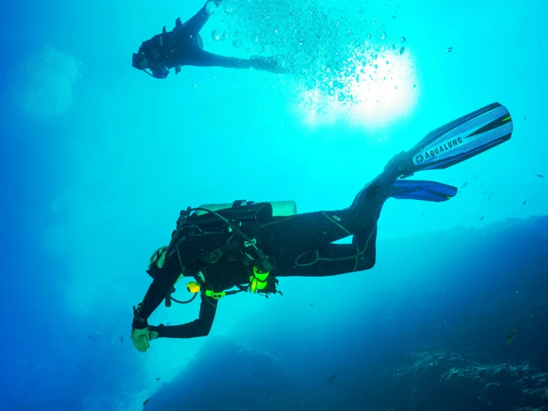 Two scuba divers in blue water